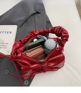 Interior view showing the large capacity of a red ruched leather crossbody bag