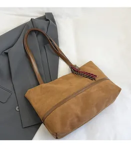 Détail du sac cabas vintage en daim marron avec pampille tissée et bandoulière chic