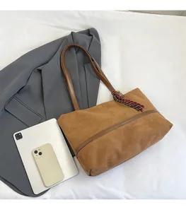 Détail du grand sac cabas en faux daim marron avec pompons tressés et grande capacité