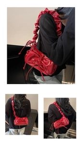 Dettaglio borsa in pelle cerata rossa con tracolla a ruches e fiocco decorativo