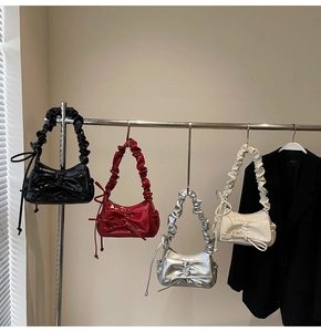 Detail of four pleated bow handbags in black, red, silver, and white glossy faux leather