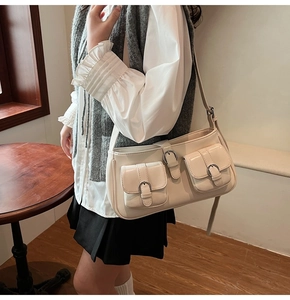 Beige Vintage-Umhängetasche mit Utensilientaschen, am Modell im gemütlichen Innenraum