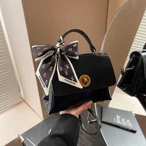 Minimalist black handbag with gold buckle and silk scarf for women stylish office commute