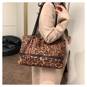 Détail du sac cabas en velours léopard avec lanières en cuir et charme en corde tissée