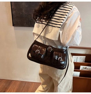 Detail der dunkelbraunen Lackledertasche mit Vintage-Taschen und silbernen Schnallen