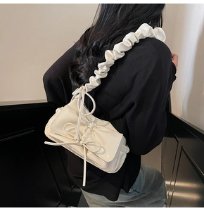 Dettaglio della borsa a tracolla bianco crema con tracolla arricciata e fiocco in stile coreano