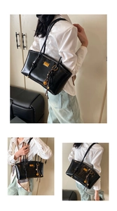 Detail of black glossy shoulder bag with golden hardware and unique pendant decoration