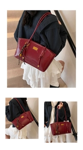 Close-up of burgundy oil wax leather tote with golden hardware and woven charm detail