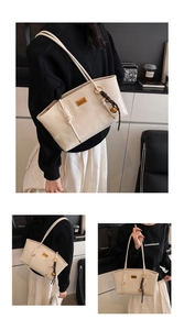 Close-up of cream shoulder tote bag with gold hardware and woven pendant detail