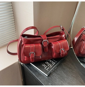 Nahaufnahme der dunkelroten Lackledertasche mit Doppeltaschen und Metallschnallen