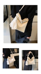 Detail of off-white large capacity bucket bag with adjustable wide strap and small pouch