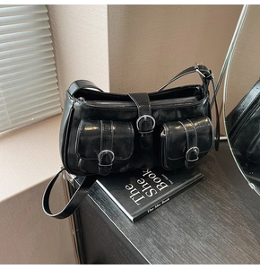 Detail einer schwarzen Vintage PU-Ledertasche mit glänzender Optik und Silberschnallen