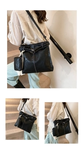 Detail of black tote bag with white contrast stitching and matching small pouch charm