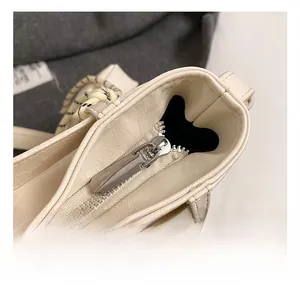Close-up of high-quality silver metal zipper on an off-white leather tote bag