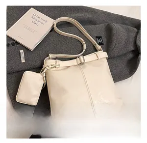 Detail of off-white bucket bag with a matching zipper pouch on textured grey wool fabric
