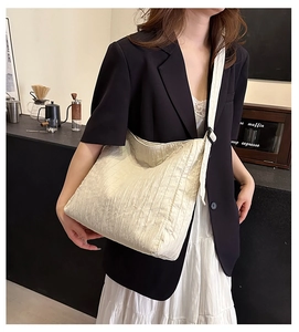 Détail du sac hobo matelassé crème avec texture gaufrée et boucle noire ajustable