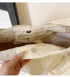 Détail du grand sac cabas crème montrant le fermoir magnétique et la poche intérieure zippée