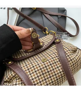 Detail of houndstooth crossbody bag showing invisible magnetic buckle and brown leather flap