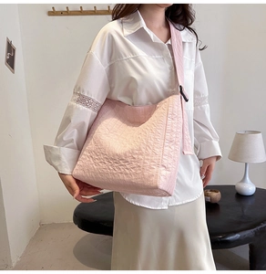 Détail d'un grand sac cabas rose en tissu texturé plissé avec bandoulière large