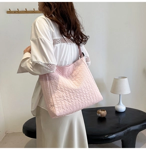 Détail d'un sac cabas rose matelassé avec rayures verticales et large bandoulière