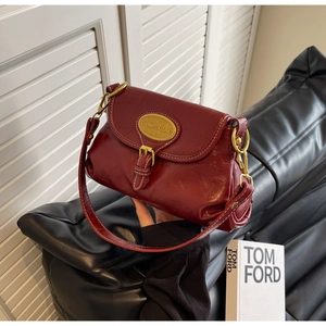 Close-up of vintage burgundy crossbody bag with oil wax leather and contrast stitching
