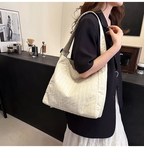 Détail du grand sac cabas blanc cassé avec design de texture plissé vertical