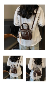 Elegant vintage brown leather crossbody handbag with white stitching and tassel detail for women