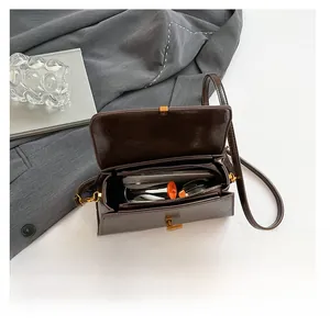 Detailansicht der braunen Umhängetasche mit Platz für Handy und Sonnenbrille im Inneren