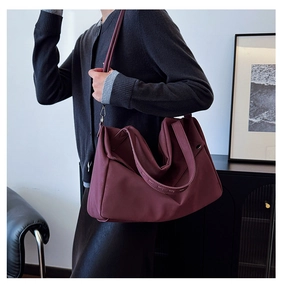 Λεπτομέρεια vintage μπορντό τσάντα tote με φαρδιές λαβές και διακοσμητικά καρφιά