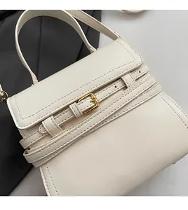 Detailweergave van de crème lederen crossbodytas met zachte textuur en gouden gesp