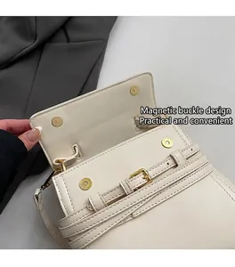 Detail van crème PU-lederen crossbodytas met dubbele magnetische sluiting en gouden hardware
