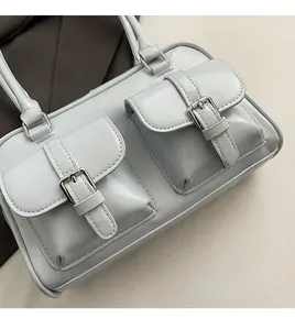 Close-up of light blue leather handbag showing silver buckles and detailed stitching