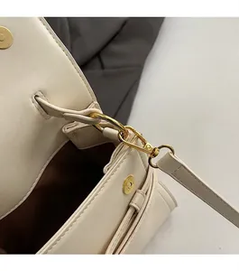 Detailopname van de gouden metalen hardware en beige lederen textuur van de tas