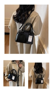 Detail of glossy black patent leather bag with a cute bear card in a clear slot