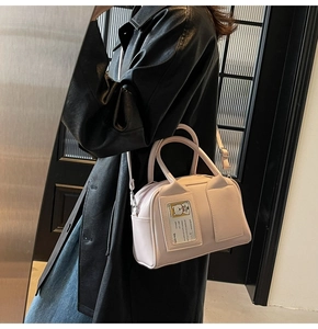 Detail of light pink leather bowling bag featuring a clear card slot with a cartoon bear