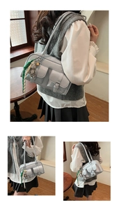 Detail of light blue glossy shoulder bag featuring double flap pockets and a bear charm