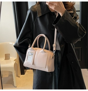 Detail of light pink Boston bag featuring transparent card slot and silver hardware