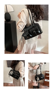 Detail of black patent leather underarm bag with pockets and astronaut charm
