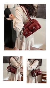 Detail of burgundy leather shoulder bag with glossy finish and silver buckles