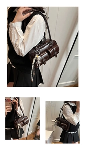 Detail view of deep brown vintage oil wax leather bag with multi-pocket design and bear charm
