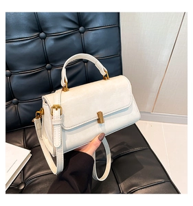 Detailansicht der weißen quadratischen Lederhandtasche mit Goldverschluss