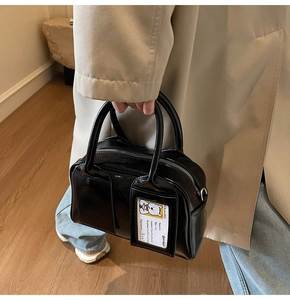 Detail of glossy black tote bag featuring a transparent card slot with a cute bear card
