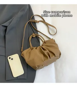 Vue détaillée d'un sac seau plissé kaki en cuir avec rivets dorés et bandoulière