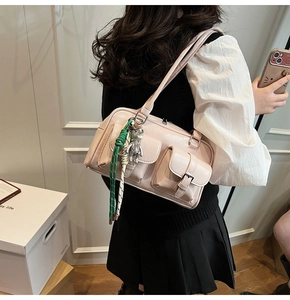 Dettaglio della borsa Boston in pelle PU rosa chiaro con doppie tasche e ciondolo a orsetto