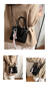 Detail of vintage black oil wax leather bucket bag with decorative tassel and metal hardware