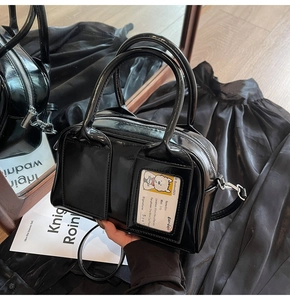 Detail of black patent leather bowling bag with silver zipper and side pocket insert