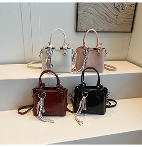 Detail showing four stylish bucket bags in ivory, pink, burgundy, and black finishes
