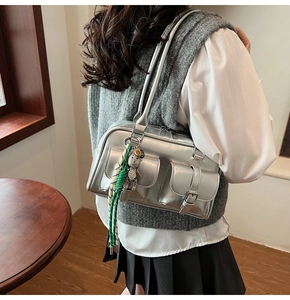 Dettaglio della borsa Boston argento con tasche a fibbia e ciondolo a forma di orso