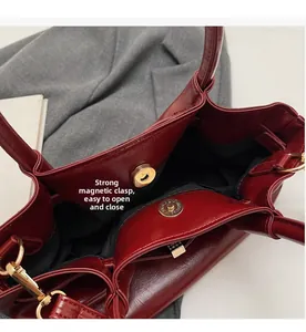 Dettaglio della borsa vintage rosso vino con fibbia magnetica dorata e fodera scura