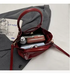 Vista dall'alto dell'interno spazioso della borsa tote bordeaux con oggetti quotidiani